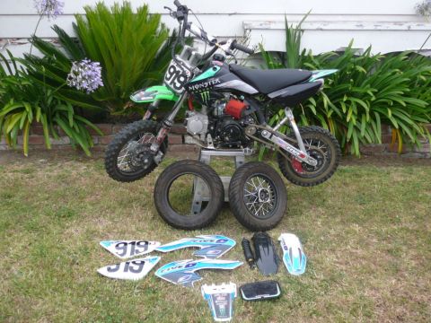 1988 Ford Bronco - Disassembled dirt bike with various parts and decals arranged on the lawn.