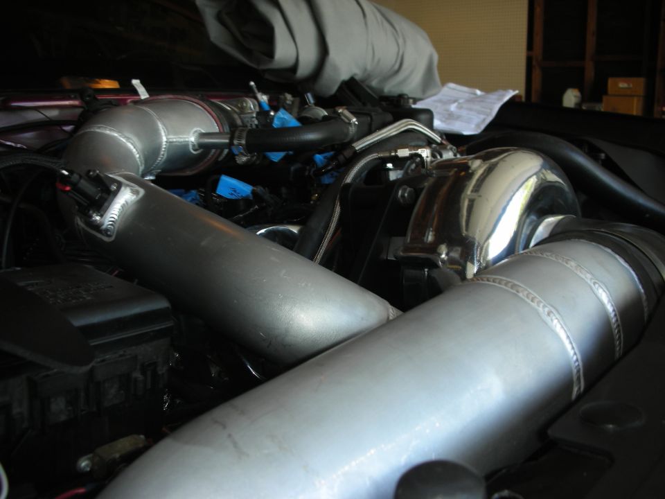Engine bay with polished metal intake pipes and turbocharger