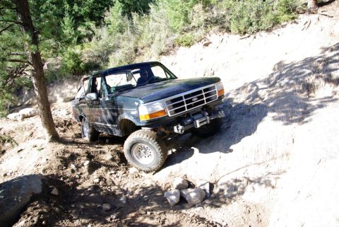 1995 Ford Bronco - This 1995 Ford Bronco navigates a challenging off-road trail with steep inclines and loose dirt.