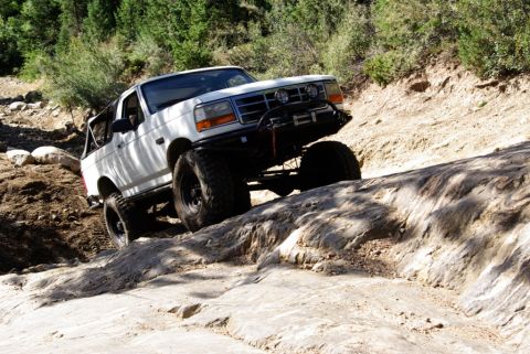 1995 Ford Bronco - This lifted 1995 Ford Bronco navigates a rocky trail with its large off-road tires.