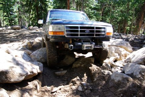1995 Ford Bronco - This 1995 Ford Bronco navigates a challenging rocky trail, equipped with a front-mounted winch.