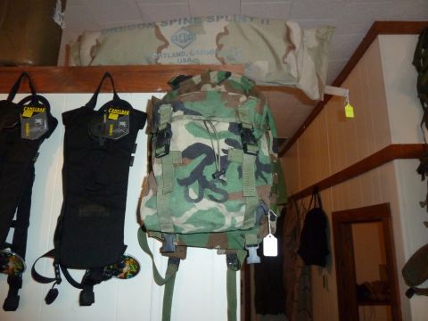 1992 Ford Mustang - A camouflage backpack and two black Camelbak hydration packs are displayed on a wall, with a rolled-up item labeled 'Oregon Spine Splint II…