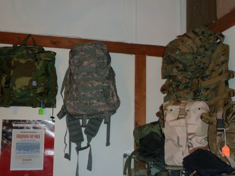 1992 Ford Mustang - Various military-style backpacks are displayed on a wall, some with camouflage patterns.