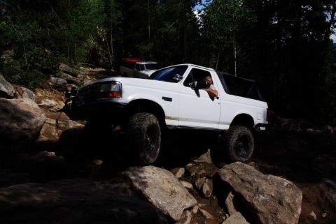 1995 Ford Bronco - This white 1995 Ford Bronco tackles a challenging rocky path during an off-road excursion.