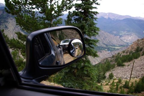 1995 Ford Bronco - Another vehicle seen on a mountain road through the side mirror.