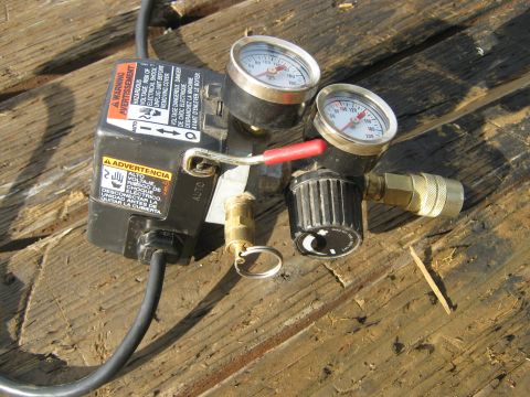 1972 Ford F-250 - Close-up of an air compressor regulator and gauges on a wooden surface.