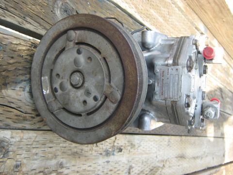 1972 Ford F-250 - A close-up view of a York Automotive air conditioning compressor, resting on weathered wooden planks.