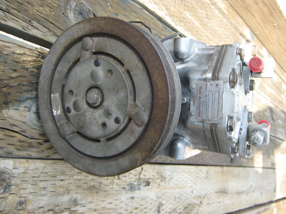 York Automotive AC compressor with pulley, sitting on wood planks