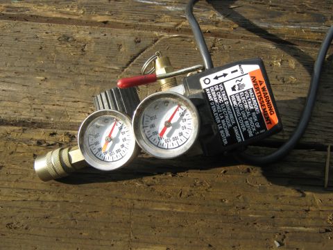 1972 Ford F-250 - A pressure regulator with two gauges and a warning label is shown on a wooden surface.