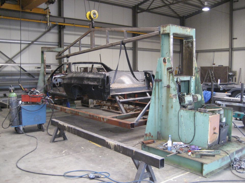 1973 Ford Ranchero body shell on a jig with welding equipment nearby