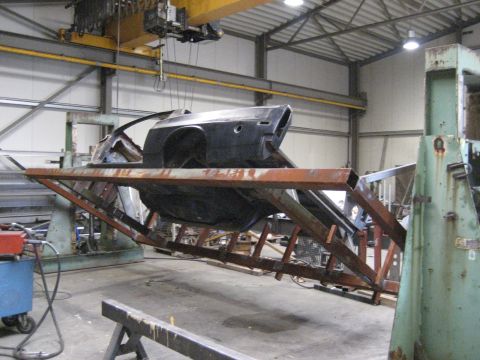 1973 Ford Ranchero - The body of a 1973 Ford Ranchero is suspended on a metal frame in a workshop, undergoing restoration.