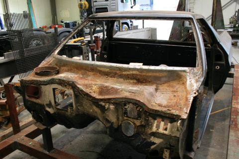1973 Ford Ranchero - This heavily rusted car body shell is missing its engine, interior, and exterior panels, making year and model identification difficult.