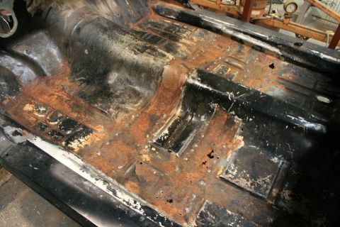 1973 Ford Ranchero - The interior floor pan of a vehicle shows significant rust and corrosion, indicating a need for extensive repair.