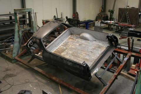 1973 Ford Ranchero - The body of a 1973 Ford Ranchero is mounted on a jig in a workshop, undergoing what appears to be a rebuild or restoration.