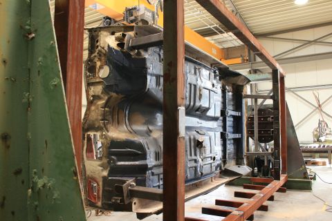 1973 Ford Ranchero - The underside of a vehicle chassis is suspended and being worked on in a repair shop.