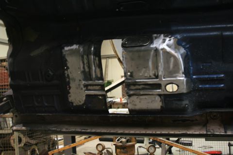 1973 Ford Ranchero - The floor pan of a vehicle shows areas of exposed metal, indicating repair work is in progress.