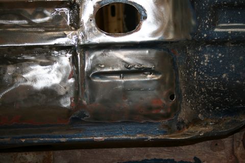 1973 Ford Ranchero - The underside of a vehicle shows areas of rust and recent welding work on the floor pan.