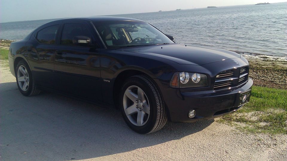 Dark blue 2006 Dodge Charger parked on a dirt road near the water