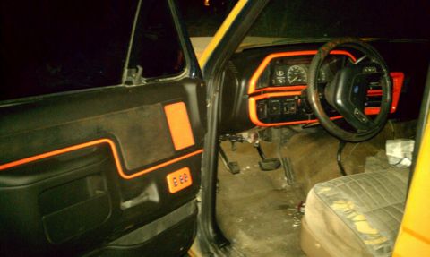 1990 Ford Bronco - The interior of this 1990 Ford Bronco features distinctive orange trim accents on the dashboard and door panels.