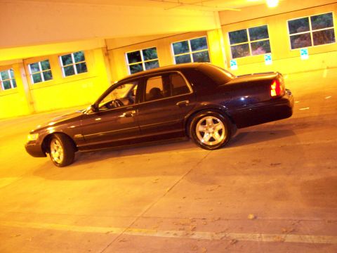 1999 Mercury Grand Marquis - A dark 1999 Mercury Grand Marquis is parked in a dimly lit garage.
