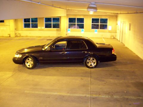 1999 Mercury Grand Marquis - A 1999 Mercury Grand Marquis is parked in a dimly lit garage, viewed from the side.