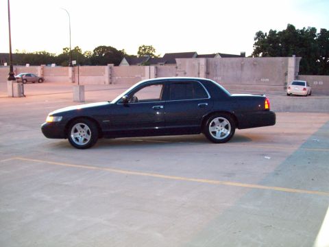 1999 Mercury Grand Marquis - Side view of a 1999 Mercury Grand Marquis parked in an outdoor lot during twilight.