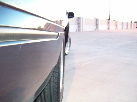 1999 Mercury Grand Marquis - Side profile of a car showing the fender, door trim, and wheel.