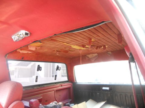 1991 Ford Bronco - The interior of a vehicle shows significant wear and tear, particularly on the headliner and padded panels.