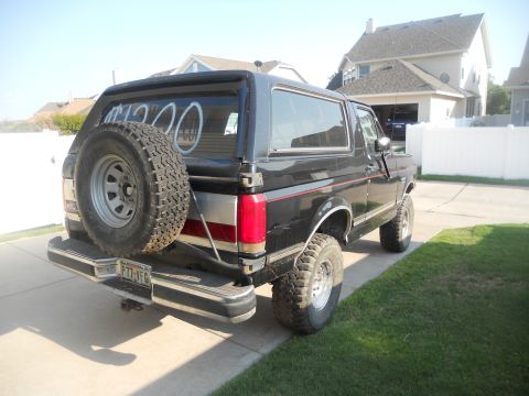 1991 Ford Bronco - This 1991 Ford Bronco is shown from the rear, a spare tire mounted on the tailgate and a two-tone stripe along the side.