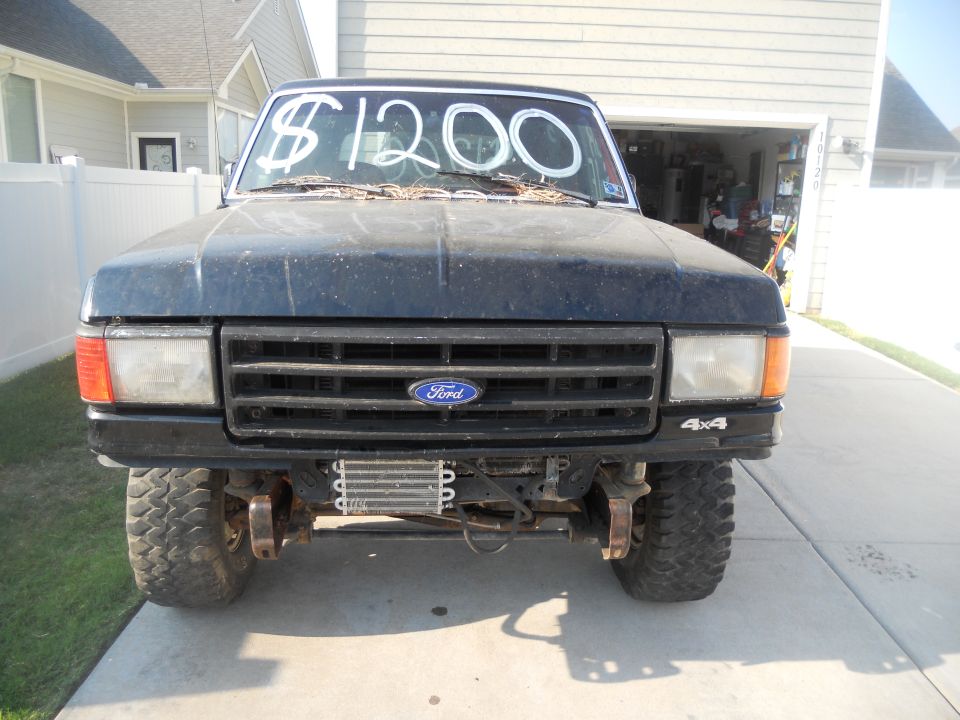 1991 Ford Bronco, dark blue, front view, with $1200 written on windshield