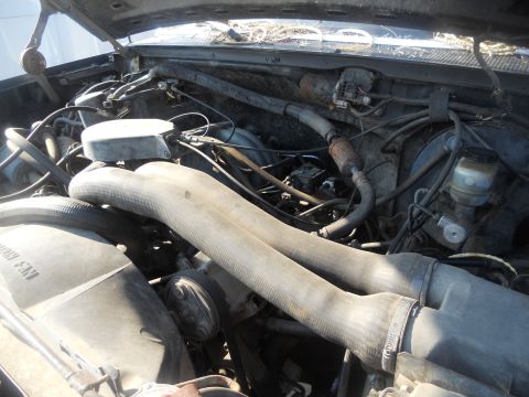 1991 Ford Bronco - Close-up view of the engine compartment, showing various hoses and components.