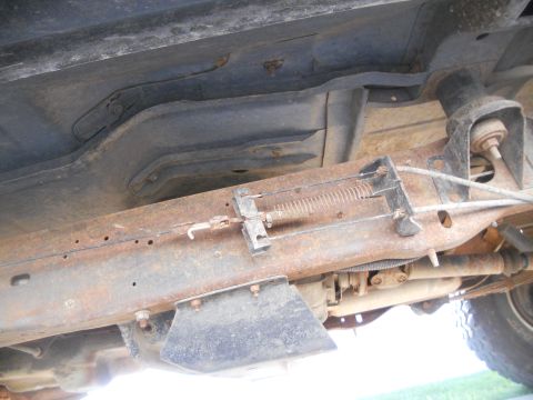 1991 Ford Bronco - The undercarriage of a vehicle shows significant rust on its frame and suspension parts.