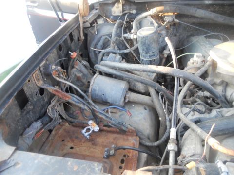 1991 Ford Bronco - The engine bay shows signs of wear and tear, with visible rust and a complex wiring system.