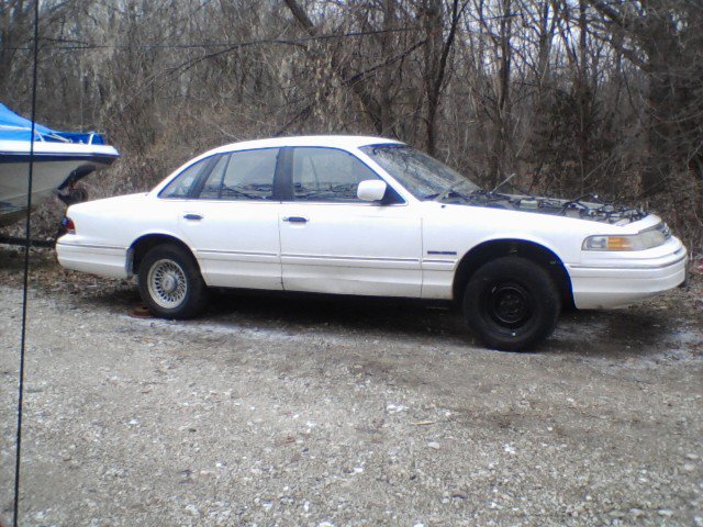 White 1994 Ford Crown Victoria sedan parked outside with hood open