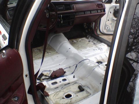 1994 Ford Crown Victoria - Interior of a 1994 Ford Crown Victoria with carpeting removed, revealing the bare metal floor.