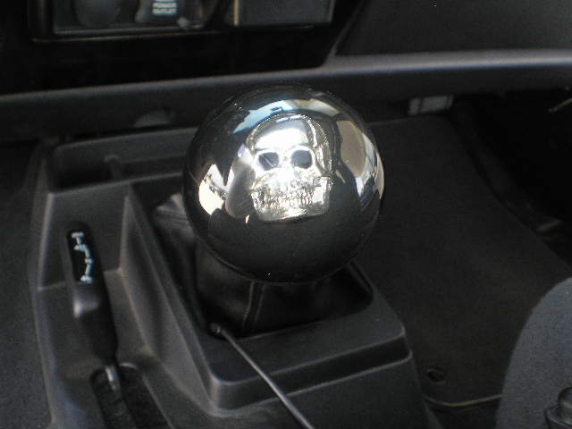 Chrome shift knob with a skull design, next to a transfer case shifter