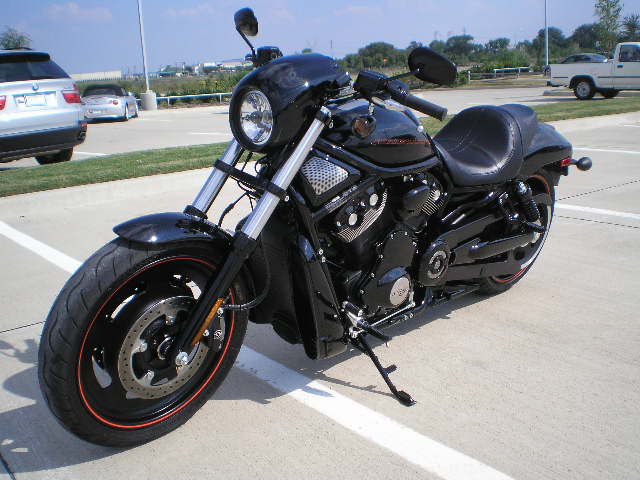 Black Harley-Davidson VROD VRSCD parked in a lot, front wheel and engine visible