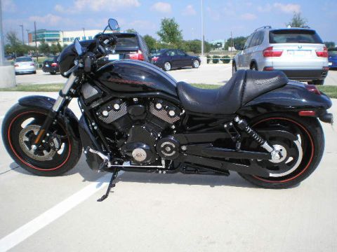 2008 Harley-Davidson VROD VRSCD - A black motorcycle with orange rim accents is parked in a lot with other vehicles.