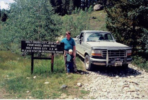 1995 Ford Bronco - A 1995 Ford F-250 truck is parked on a gravel road next to a sign indicating the Holy Cross City Jeep Road.