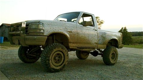 1995 Ford F-150 - This lifted Ford F-150 pickup truck is covered in mud, suggesting off-road use.