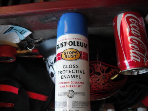 1991 Ford Bronco - A can of spray paint and a soda can sit on a shelf, surrounded by other items.