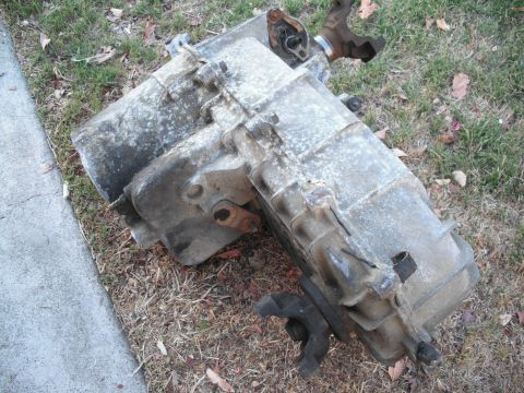 1991 Ford Bronco - This transfer case, possibly from a 1991 Ford Bronco, is shown outdoors on the ground.