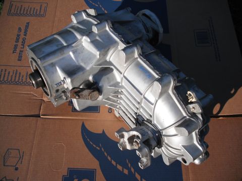 1991 Ford Bronco - Transfer case shown resting on cardboard boxes. Blue writing is visible on the top casing.
