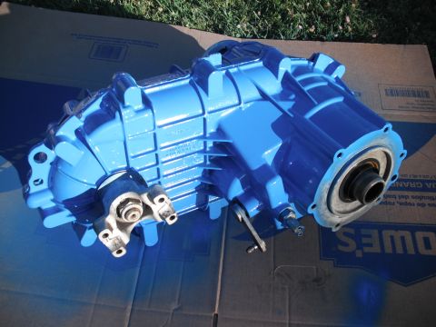 1991 Ford Bronco - A freshly painted blue transfer case rests on a cardboard box outdoors.