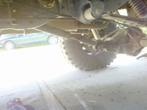 1989 Ford Bronco - Undercarriage view shows the rear axle, suspension, and tire of a vehicle.