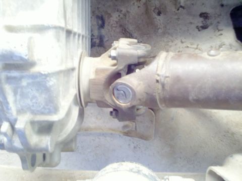 1989 Ford Bronco - This image shows a close-up view of a vehicle's drivetrain components, specifically the driveshaft and transfer case connection.