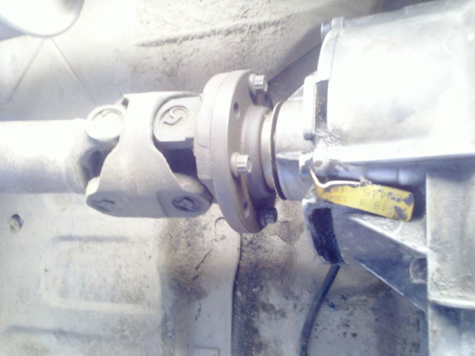 Driveshaft connected to a transmission housing with a yellow tag attached