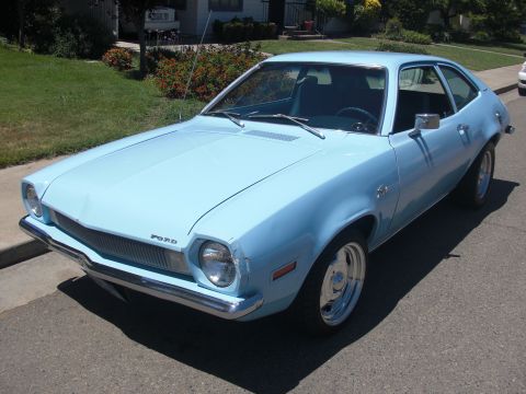 1972 Ford Pinto - A light blue 1972 Ford Pinto is parked on a street in front of a house.