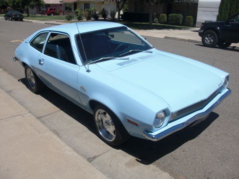 1972 Ford Pinto - A light blue 1972 Ford Pinto coupe is parked on a street in a residential neighborhood.