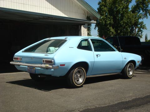 1972 Ford Pinto - A light blue 1972 Ford Pinto hatchback is seen from the rear quarter angle in front of a residential garage.